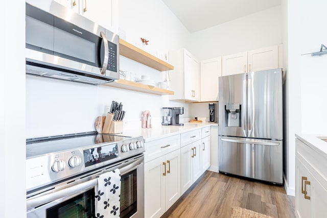 1900 12th Ave S Unit 502, Nashville, TN 37203 - kitchen with appliances with stainless steel finishes, open shelves, light wood-style flooring, and white cabinets