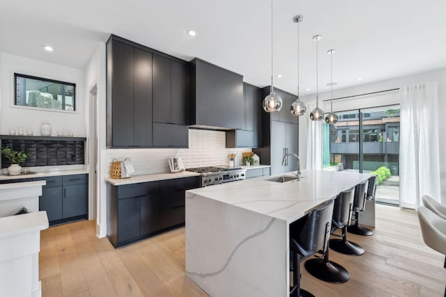 112 47th Ave N, Nashville, TN 37209 - kitchen with stainless steel range, a sink, modern cabinets, backsplash, and light wood finished floors