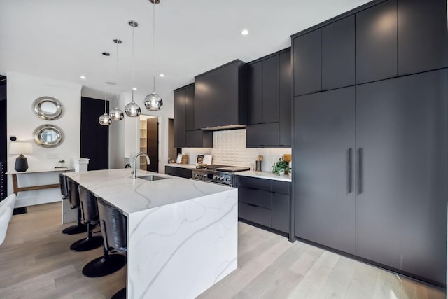 112 47th Ave N, Nashville, TN 37209 - kitchen with a sink, dark cabinetry, modern cabinets, a spacious island, and tasteful backsplash