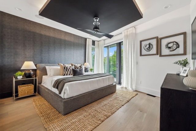 112 47th Ave N, Nashville, TN 37209 - bedroom with access to exterior, baseboards, light wood-style floors, a raised ceiling, and a ceiling fan