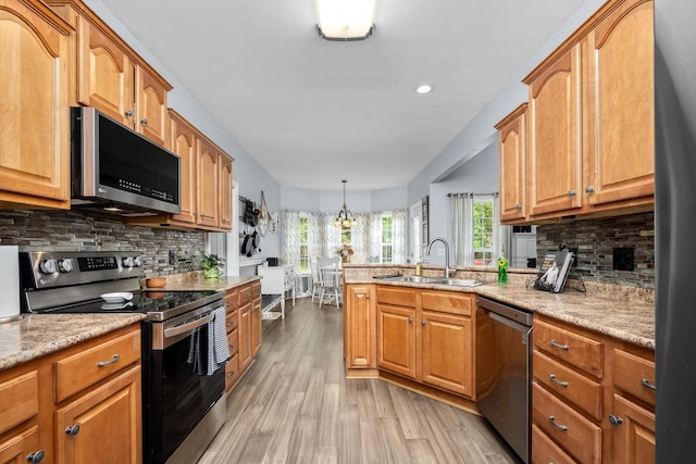 116 Macy Ct, Christiana, TN 37037 - kitchen with stainless steel appliances, a sink, light wood-style floors, a peninsula, and tasteful backsplash