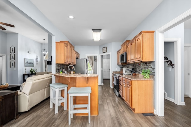 116 Macy Ct, Christiana, TN 37037 - kitchen with appliances with stainless steel finishes, a peninsula, tasteful backsplash, a breakfast bar area, and recessed lighting