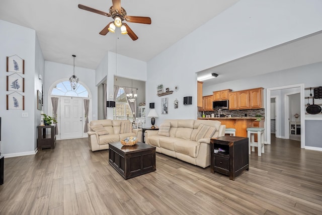 116 Macy Ct, Christiana, TN 37037 - living room featuring a chandelier, high vaulted ceiling, light wood-style floors, a ceiling fan, and baseboards