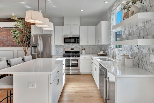 603 51st Ave, Nashville, TN 37209 - kitchen with stainless steel appliances, a breakfast bar area, a sink, a wall mounted air conditioner, and white cabinets