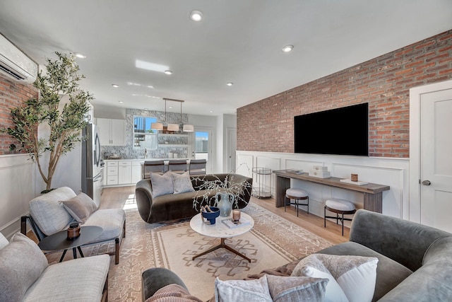 603 51st Ave, Nashville, TN 37209 - living room with light wood-type flooring, an AC wall unit, wainscoting, brick wall, and recessed lighting