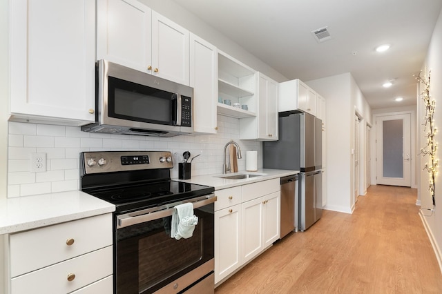 600 E Trinity Ln Unit 20, Nashville, TN 37207 - kitchen with appliances with stainless steel finishes, a sink, light wood-type flooring, open shelves, and white cabinetry