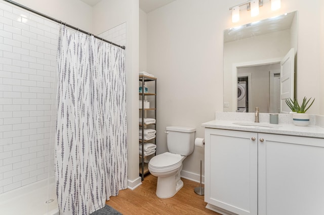 600 E Trinity Ln Unit 20, Nashville, TN 37207 - bathroom featuring stacked washer / dryer, toilet, wood finished floors, vanity, and tiled shower
