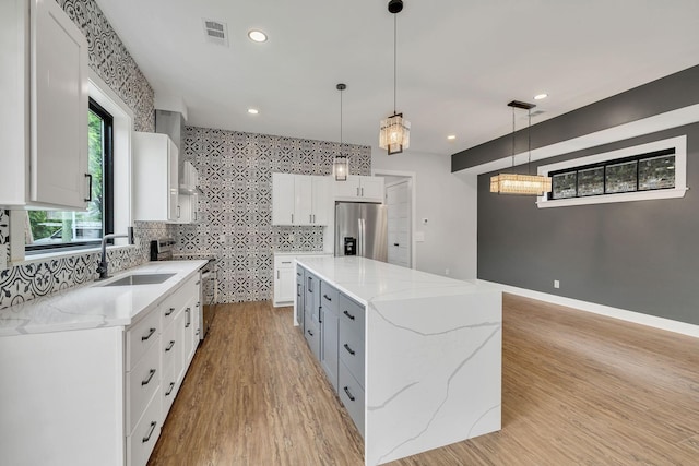 415 S University St, Murfreesboro, TN 37130 - kitchen with stainless steel refrigerator with ice dispenser, a sink, a spacious island, white cabinets, and electric range