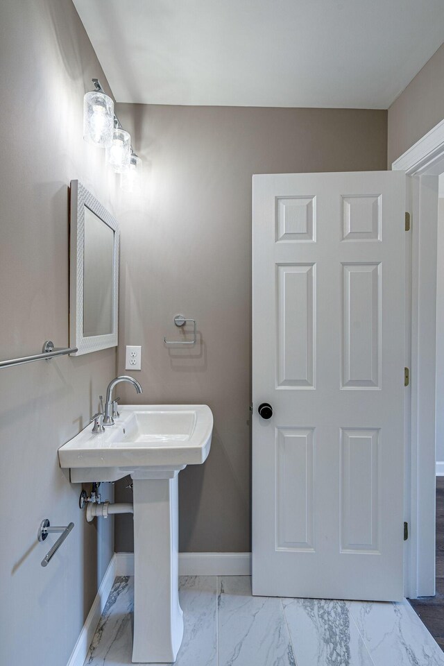 4626 Cato Rd, Nashville, TN 37218 - bathroom featuring marble look tiles, baseboards, and a sink
