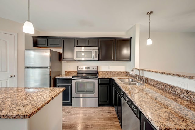 133 Cobblestone Place Dr, Goodlettsville, TN 37072 - kitchen with stainless steel appliances, a sink, light wood-style flooring, light stone countertops, and hanging light fixtures
