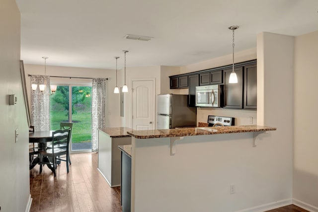 133 Cobblestone Place Dr, Goodlettsville, TN 37072 - kitchen with stainless steel appliances, a kitchen breakfast bar, wood finished floors, and dark stone countertops