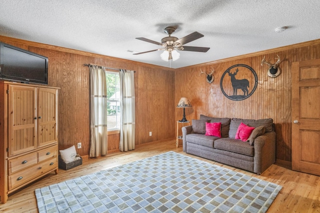 29 Roger Monk Rd, Petersburg, TN 37144 - living area featuring light wood-style flooring, wood walls, a ceiling fan, crown molding, and a textured ceiling