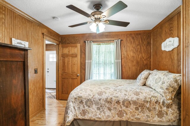 29 Roger Monk Rd, Petersburg, TN 37144 - bedroom featuring multiple windows, light wood finished floors, ornamental molding, wooden walls, and a textured ceiling