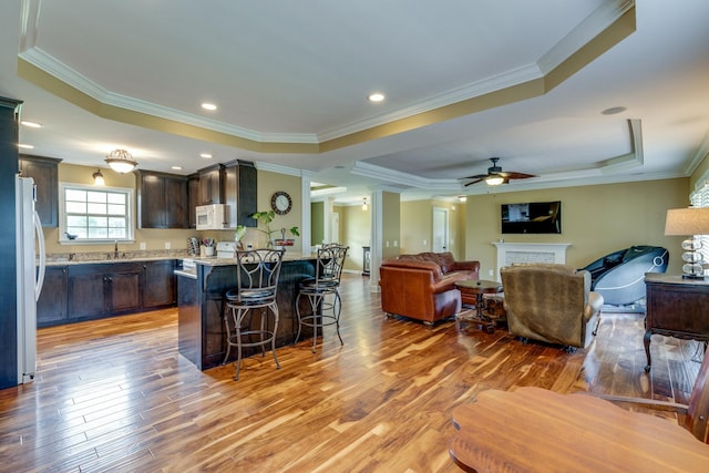 234 Glenn Springs Rd, Lawrenceburg, TN 38464 - kitchen featuring white appliances, a raised ceiling, a kitchen breakfast bar, dark brown cabinetry, and light wood-style floors