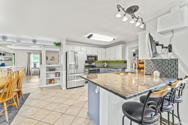 4312 Seminary Rd, Smyrna, TN 37167 - kitchen with appliances with stainless steel finishes, a peninsula, a sink, ornamental molding, and light tile patterned flooring