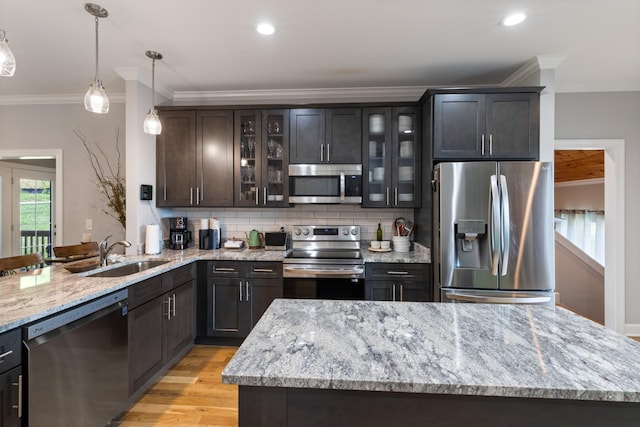 111 Madeleine Way, Kingston Springs, TN 37082 - kitchen featuring appliances with stainless steel finishes, a sink, crown molding, hanging light fixtures, and backsplash