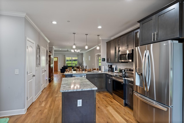 111 Madeleine Way, Kingston Springs, TN 37082 - kitchen featuring stainless steel appliances, ornamental molding, a peninsula, recessed lighting, and a center island