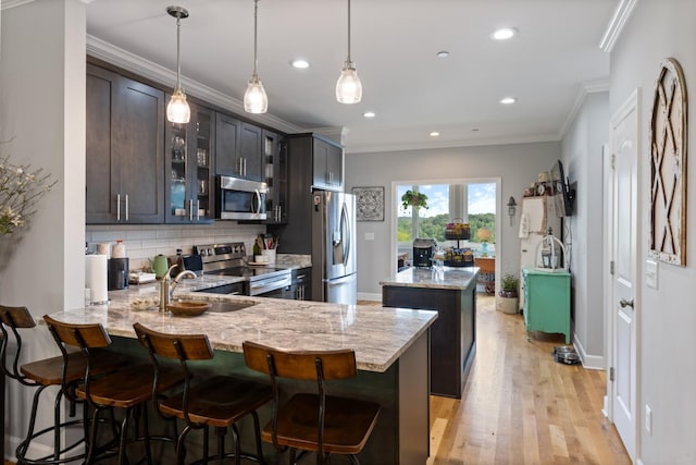 111 Madeleine Way, Kingston Springs, TN 37082 - kitchen featuring appliances with stainless steel finishes, a sink, a peninsula, tasteful backsplash, and a center island