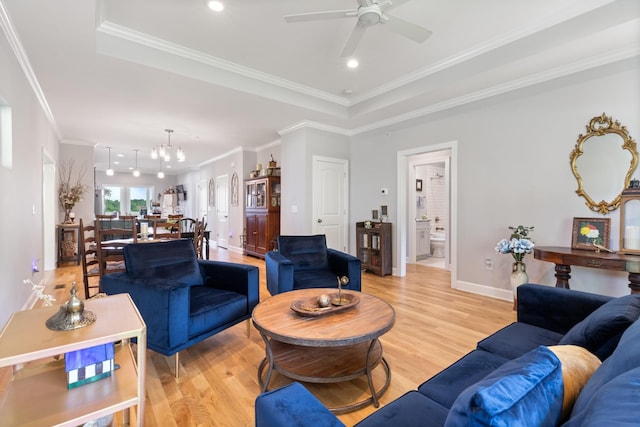 111 Madeleine Way, Kingston Springs, TN 37082 - living room with a tray ceiling, light wood-style flooring, ceiling fan, a chandelier, and ornamental molding