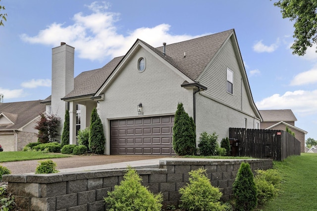 904 Park Crest Ct, Mount Juliet, TN 37122 - view of side of property with a chimney, driveway, a shingled roof, and an attached garage