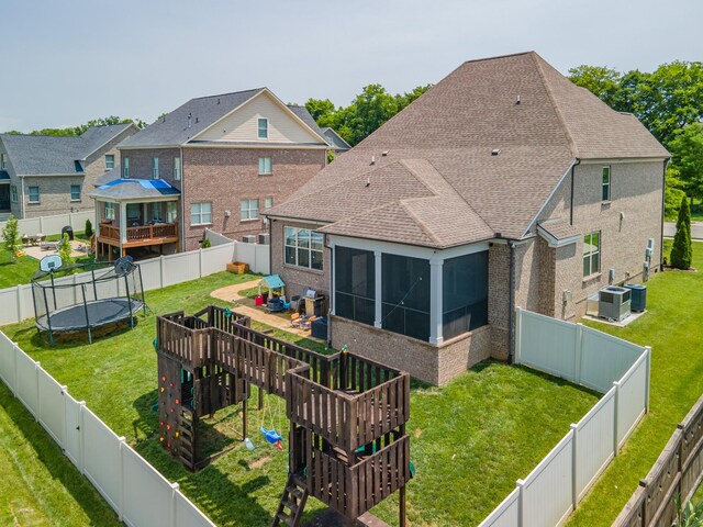 705 Rain Meadow Ct, Spring Hill, TN 37174 - rear view of house featuring a trampoline, a sunroom, brick siding, a wooden deck, and a shingled roof