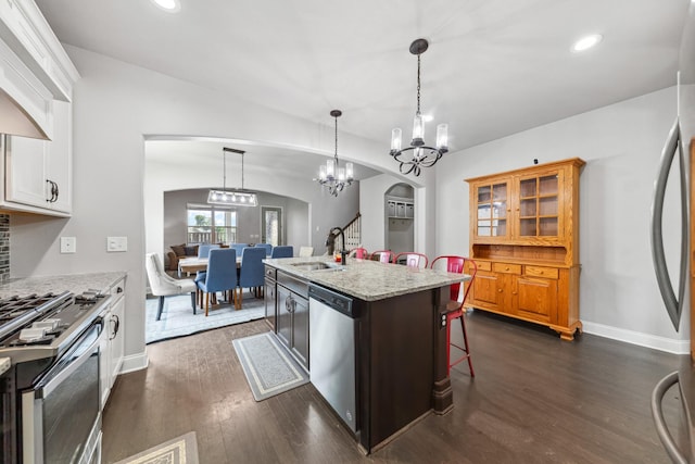 705 Rain Meadow Ct, Spring Hill, TN 37174 - kitchen featuring stainless steel appliances, arched walkways, a breakfast bar area, dark wood-style flooring, and recessed lighting