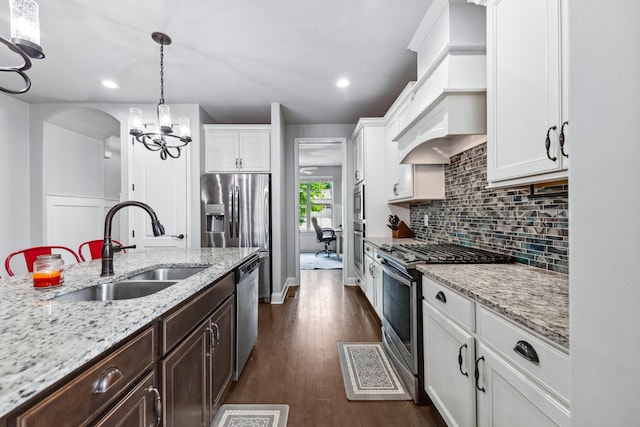 705 Rain Meadow Ct, Spring Hill, TN 37174 - kitchen featuring stainless steel appliances, white cabinetry, dark brown cabinets, custom range hood, and decorative backsplash