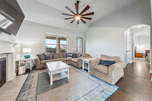 705 Rain Meadow Ct, Spring Hill, TN 37174 - living area with vaulted ceiling, ceiling fan, arched walkways, a tile fireplace, and wood finished floors