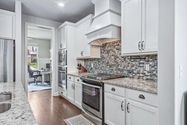 705 Rain Meadow Ct, Spring Hill, TN 37174 - kitchen with appliances with stainless steel finishes, custom range hood, white cabinetry, tasteful backsplash, and dark wood-type flooring
