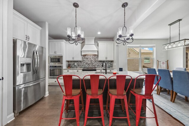 705 Rain Meadow Ct, Spring Hill, TN 37174 - kitchen featuring stainless steel appliances, a chandelier, custom exhaust hood, backsplash, and a kitchen island with sink