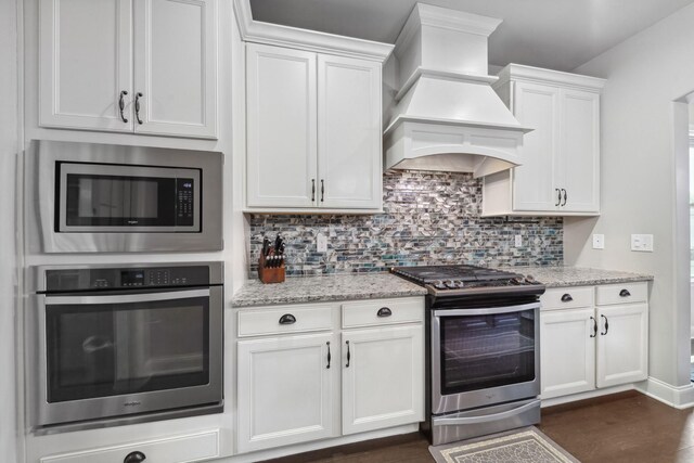 705 Rain Meadow Ct, Spring Hill, TN 37174 - kitchen featuring stainless steel appliances, custom range hood, decorative backsplash, and white cabinetry