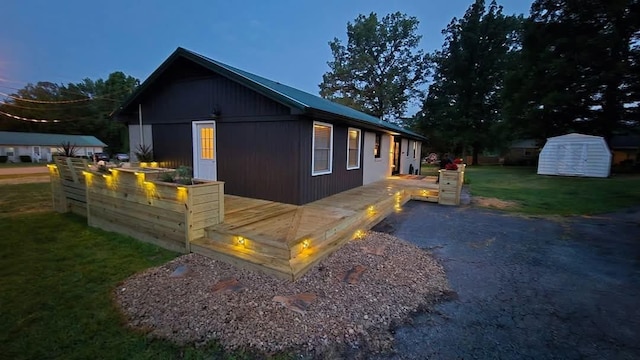 371 Leader Dr, New Johnsonville, TN 37134 - view of side of home with a lawn, a wooden deck, and a storage unit