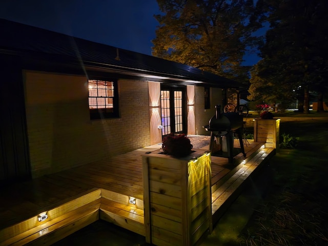 371 Leader Dr, New Johnsonville, TN 37134 - back of house at twilight featuring french doors, a wooden deck, and brick siding