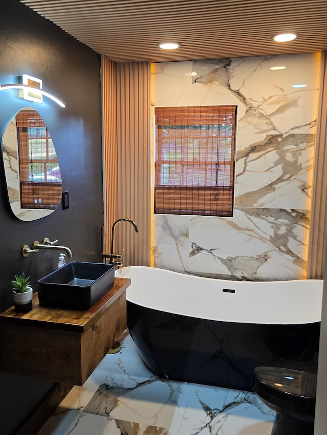 371 Leader Dr, New Johnsonville, TN 37134 - bathroom featuring marble tiled floors, a freestanding bath, recessed lighting, and vanity