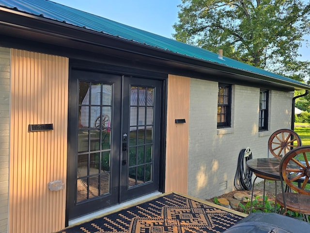 371 Leader Dr, New Johnsonville, TN 37134 - view of exterior entry with french doors, brick siding, and a metal roof
