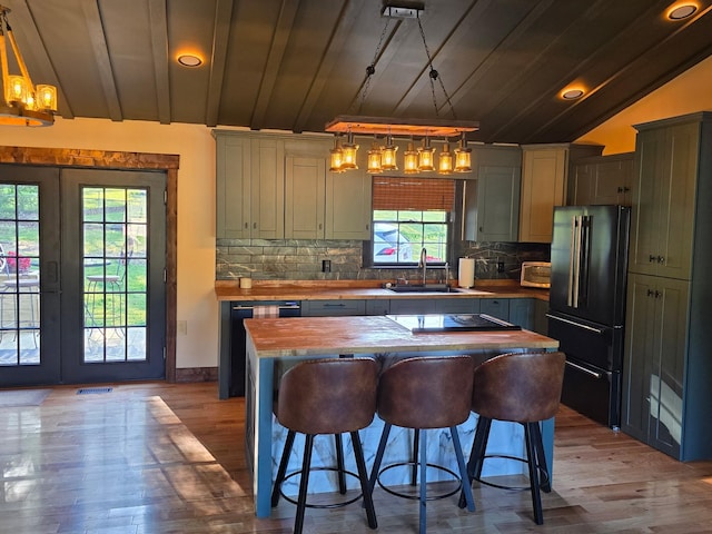 371 Leader Dr, New Johnsonville, TN 37134 - kitchen with black appliances, wood counters, a chandelier, wood finished floors, and vaulted ceiling