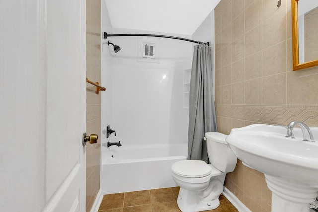 2134 Fairfax Ave Unit A1, Nashville, TN 37212 - bathroom featuring tile walls, shower / bathtub combination with curtain, toilet, a sink, and tile patterned floors