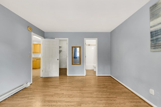 2134 Fairfax Ave Unit A1, Nashville, TN 37212 - unfurnished bedroom with a baseboard radiator, a walk in closet, light wood-style floors, connected bathroom, and baseboards