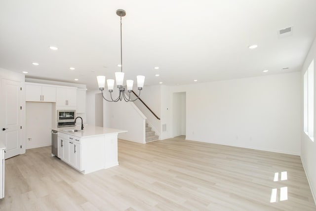 2367 Williamsport Lndg, Columbia, TN 38401 - kitchen with light wood-style flooring, white cabinets, light countertops, a chandelier, and a sink