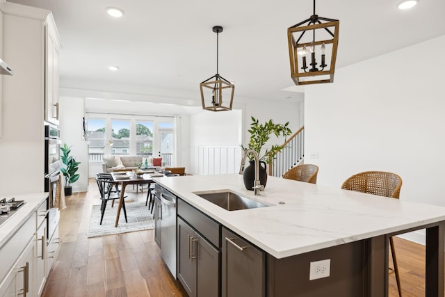 3298 Vinemont Dr, Thompsons Station, TN 37179 - kitchen featuring a sink, dishwasher, light wood-style flooring, open floor plan, and a center island with sink