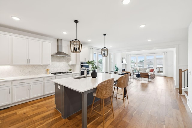 3298 Vinemont Dr, Thompsons Station, TN 37179 - kitchen with wall chimney exhaust hood, gas stovetop, a sink, light countertops, and white cabinets