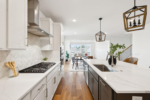 3298 Vinemont Dr, Thompsons Station, TN 37179 - kitchen with wall chimney range hood, a sink, appliances with stainless steel finishes, light wood-type flooring, and white cabinetry