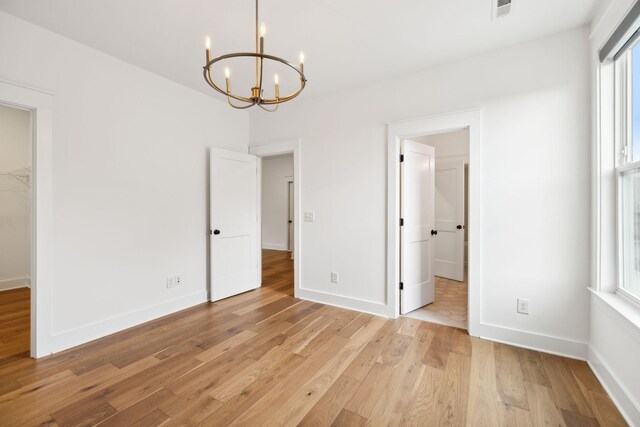 3298 Vinemont Dr, Thompsons Station, TN 37179 - unfurnished bedroom with a chandelier, light wood-style floors, and baseboards