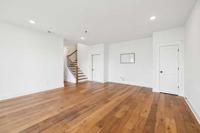 3298 Vinemont Dr, Thompsons Station, TN 37179 - empty room featuring stairs, light wood finished floors, baseboards, recessed lighting, and a pendent fire sprinkler