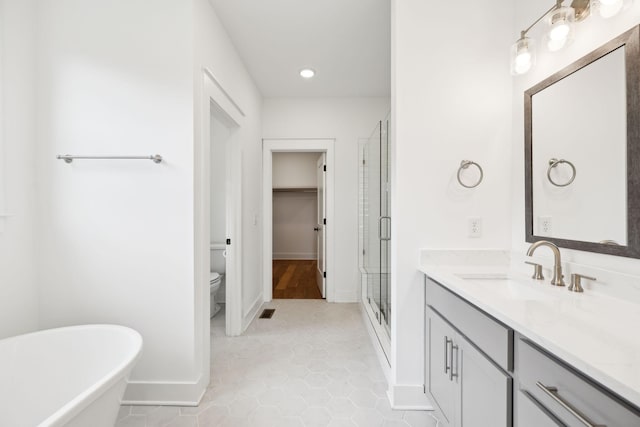 3298 Vinemont Dr, Thompsons Station, TN 37179 - full bathroom featuring vanity, a shower stall, baseboards, a freestanding tub, and toilet