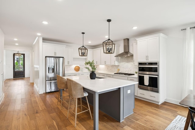 3298 Vinemont Dr, Thompsons Station, TN 37179 - kitchen with appliances with stainless steel finishes, wall chimney range hood, decorative backsplash, a kitchen island, and white cabinetry