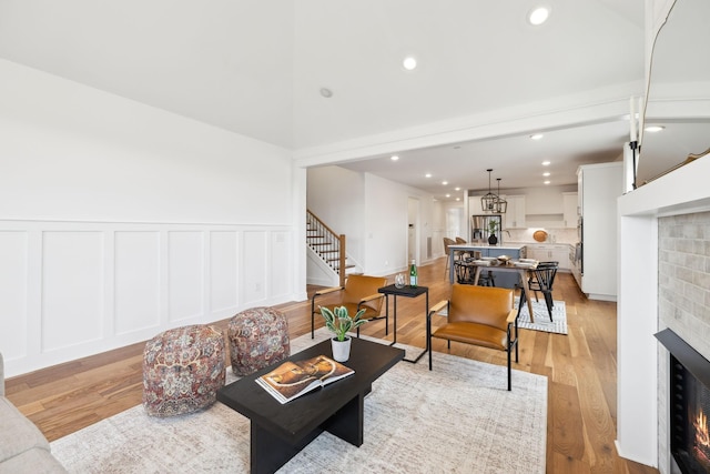 3298 Vinemont Dr, Thompsons Station, TN 37179 - living area with a warm lit fireplace, stairs, recessed lighting, a decorative wall, and a wainscoted wall