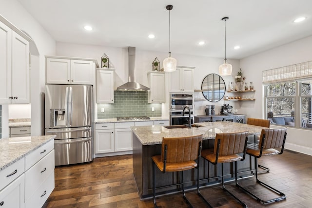 413 Eagle Rdg, Nashville, TN 37209 - kitchen featuring appliances with stainless steel finishes, wall chimney range hood, a sink, dark wood-style floors, and white cabinets