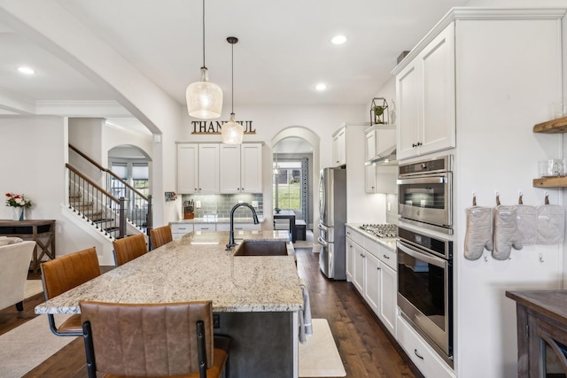 413 Eagle Rdg, Nashville, TN 37209 - kitchen with a sink, arched walkways, appliances with stainless steel finishes, a kitchen bar, and recessed lighting