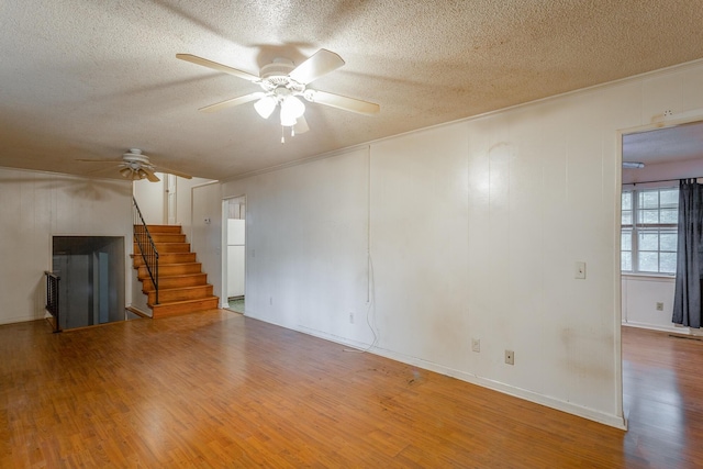 4510 Ravenwood Dr E, Chattanooga, TN 37415 - unfurnished living room featuring a ceiling fan, a textured ceiling, wood finished floors, stairway, and ornamental molding